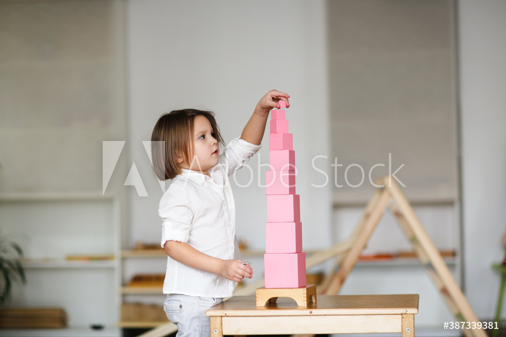 child girl playing with pink tower, developing sensory activities in montessori and earlier child development, kids independence